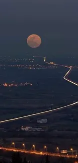 Moonlit highway under a full moon with urban lights