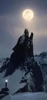 Dramatic moonlight mountain with a climber silhouetted against the night sky.