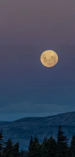 Full moon over a serene mountain landscape at night.