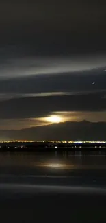 Night landscape with moonlit mountains and lake reflection.