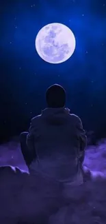 Person gazing at full moon in deep blue night sky, surrounded by misty clouds.