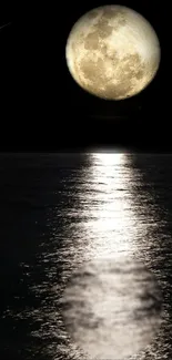 Full moon reflecting over a calm water surface at night.