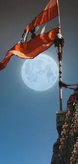 Temple silhouette with a waving flag against a full moon.