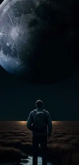 A person gazing up at a massive moon in a dark, open landscape.