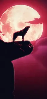 Silhouette of a wolf against a full red moon on a cliff.