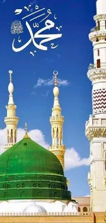 Mosque dome and minarets under a vivid blue sky with Arabic script.