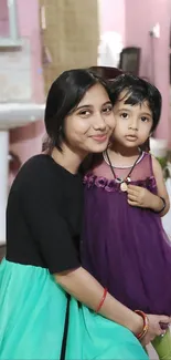 Mother and daughter smiling together indoors.