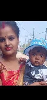 Mother holding child in traditional outfit.