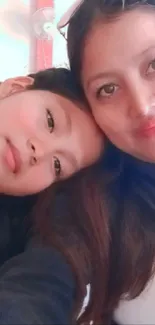 Mother and daughter smiling in a close embrace.