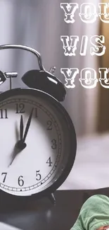Alarm clock and 'You vs You' quote on desk wallpaper.