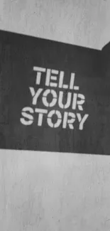 Inspirational wallpaper with 'Tell Your Story' in black stencil on grey background.