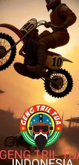 Motocross biker performing a jump at sunset.