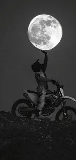 Motocross rider reaching for the moon in a black and white scene.