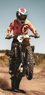 Motocross rider performing stunt on dirt track.