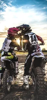 Two motocross riders share a sunset moment.