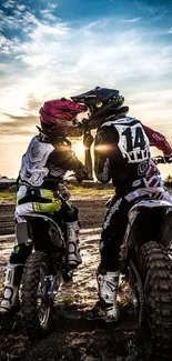 Motocross riders with helmets at sunset.