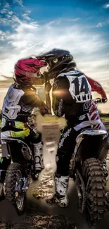 Two motocross riders under a stunning sunset sky.