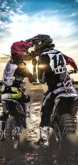 Motocross riders riding into the sunset on a dirt track.