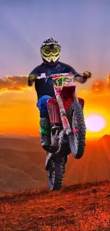 Motocross rider jumping at sunset with orange sky backdrop.