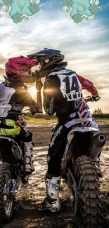 Motocross bikers riding at sunset on a dirt track.