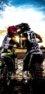Motocross riders at sunset with dramatic sky.