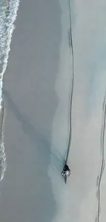 Aerial view of a motorbike on a sandy beach with turquoise waves.