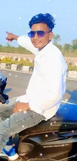 Young man on a motorbike under a clear blue sky.