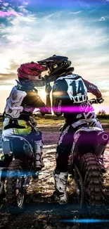 Two motocross riders sharing a moment at sunset on a dirt track.