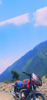 Motorcycle on scenic mountain road under blue sky.