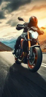 Motorcyclist racing through mountain roads under a vibrant sunset sky.