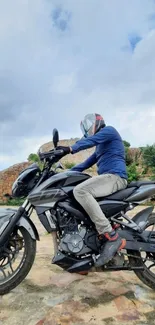 Motorcyclist on a bike with a scenic nature backdrop under a blue sky.