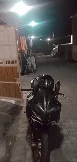 Sleek black motorcycle parked at night.