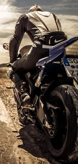 Motorcyclist rides along open road under expansive sky.