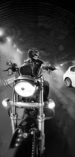 Motorcyclist riding through a lit tunnel, black and white effect.