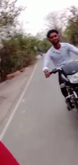 Motorcycle ride on a scenic road with trees.