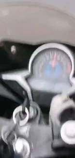 Blurred view of a motorcycle speedometer with key in ignition.