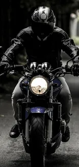 Motorcyclist in black gear riding through a dark alley.