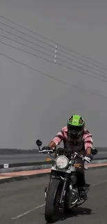 Motorcyclist riding on a grey road under cloudy skies.