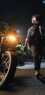 Motorcyclist walking beside a bike at night with streetlights.