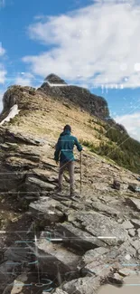 Hiker on rugged mountain trail beneath blue sky wallpaper.