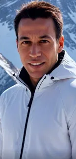 Man in white jacket with snowy mountain backdrop