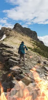 Man hiking rugged mountain trail with fiery accents and a blue sky backdrop.