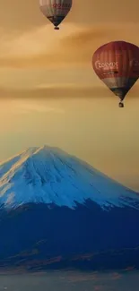 Hot air balloons over a snow-capped mountain.