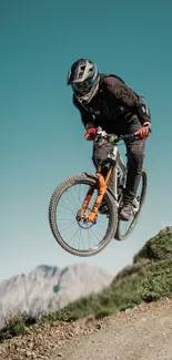 Cyclist jumping on mountain bike against clear sky.