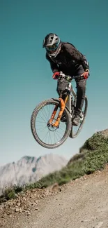 Mountain biker catching air on a trail with a scenic backdrop.