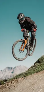 Mountain biker mid-jump on trail with scenic background.