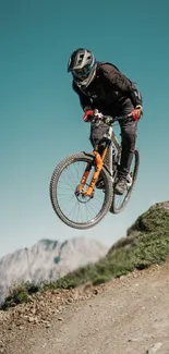 Cyclist jumping in rugged mountain biking terrain with teal sky backdrop.
