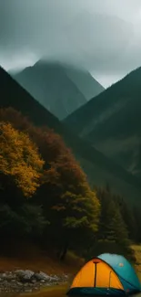 Scenic mountain view with tent and misty peaks.