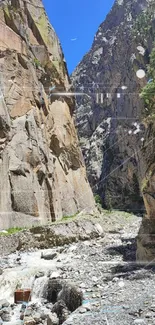 Serene mountain canyon with rocks and blue sky.