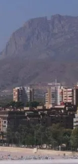 City buildings with mountain backdrop in mobile wallpaper.